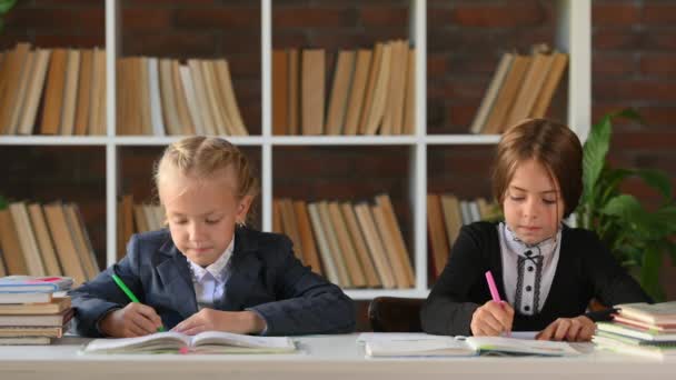 Дві Милі Школярки Сидять Столом Бібліотекою Або Роблять Домашнє Завдання — стокове відео