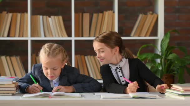 Dos Colegialas Lindas Sentadas Escritorio Mesa Biblioteca Casa Miran Por — Vídeos de Stock