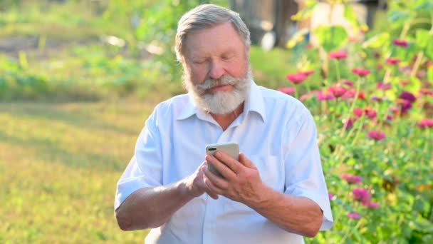 Närbild Äldre Manlig Bonde Med Skägg Använda Smartphone För Kommunikation — Stockvideo