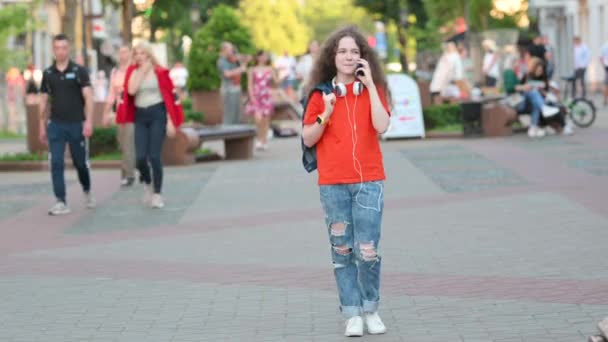 Kulaklıklı Genç Kız Şehirde Gezintide Konuşuyor Şehir Caddesinde Öğrenci Letişimi — Stok video
