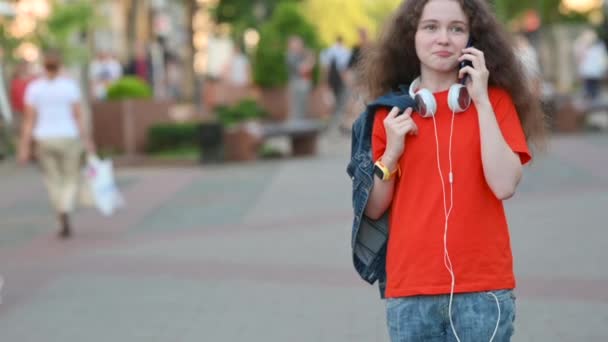Genç Çekici Kız Smartphone Sokakta Yürüyen Şehir Haberleşmesi Boynunda Kulaklık — Stok video