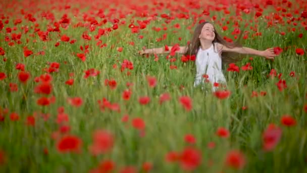 Roztomilá holčička v krásných bílých šatech procházky a má zábavu na poli červených máků. Šťastná dívka na poli kvetoucích máků. Volný čas v přírodě. Užívám si přírodu. Léto