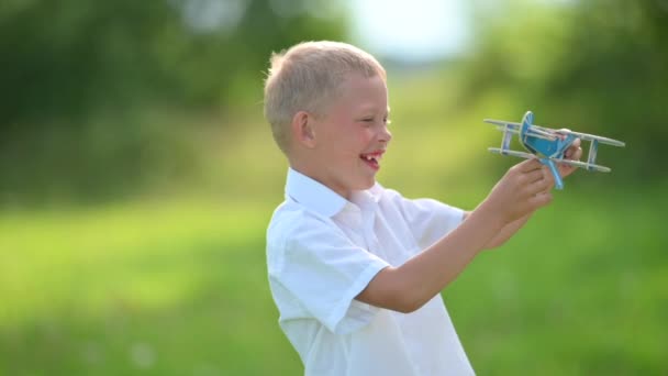 Glad Leende Pojke Med Trä Leksak Flygplan Modell Spelar Fältet — Stockvideo