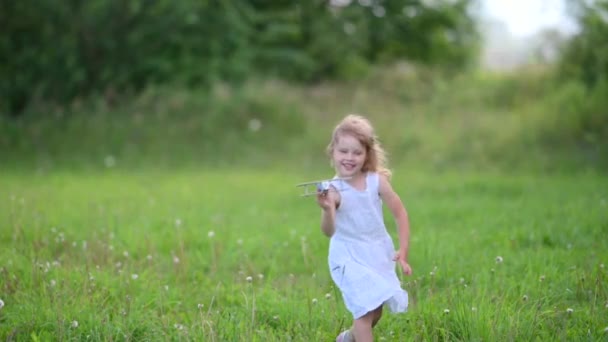 快乐微笑的女孩与木制玩具平面模型在战场上的游戏 孩子的梦想 慢动作 — 图库视频影像