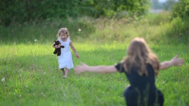 ママと子供が公園で遊んでる 幸せな子供は抱擁でお母さんに実行されます キスして幸せな家族を抱きしめる 幸せな家族のコンセプト — ストック動画