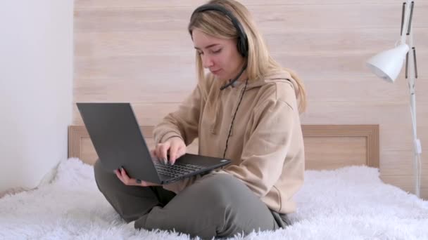 Uma Jovem Fones Ouvido Trabalha Casa Para Laptop Enquanto Está — Vídeo de Stock