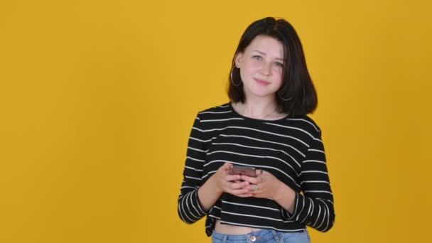 Retrato Niña Feliz Con Teléfono Aislado Fondo Del Estudio Amarillo — Vídeos de Stock