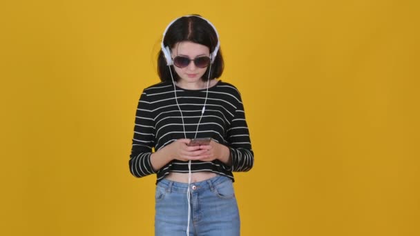Porträt Eines Jungen Mädchens Mit Sonnenbrille Und Kopfhörer Hört Musik — Stockvideo