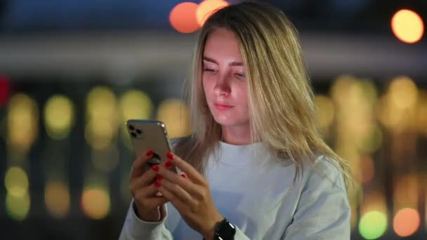 Gece Kasabasında Yürüyüş Sırasında Cep Telefonu Kullanan Mutlu Genç Kız — Stok video