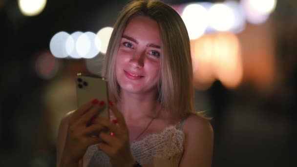 Gece Kasabası Nın Caddelerinde Yürürken Cep Telefonu Kullanan Mutlu Genç — Stok video
