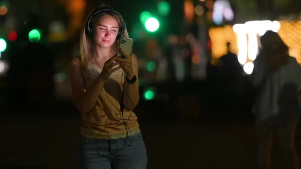 Jonge Vrolijke Vrouw Die Muziek Luistert Een Koptelefoon Streets Night — Stockvideo