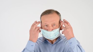 Stüdyoda izole edilmiş tıbbi maske takan yaşlı bir adamın portresi. Kapsamlı sağlık ve güvenlik kavramı. Sağlık ve Sağlık Hizmetleri.