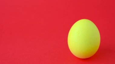 Kırmızı arka planda sarı paskalya yumurtası. Mesaj için yer var. Paskalya yumurtası yakın plan..