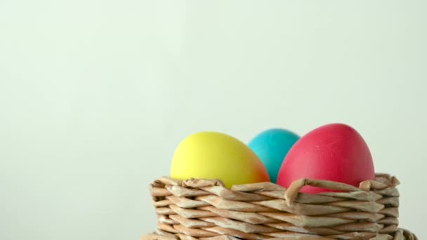 复活节装饰 五彩缤纷的彩蛋在白色背景的篮子里旋转着 复活节彩蛋特写 — 图库视频影像