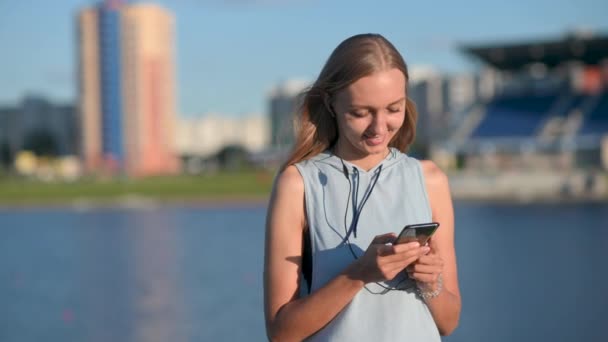 Strzał Zwolnionym Tempie Młodej Uśmiechniętej Dziewczyny Odzieży Sportowej Pomocą Smartfona — Wideo stockowe