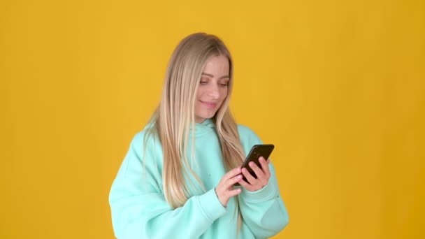 Happy Young Blonde Girl Using Smart Phone Texting Online Chat — Stock Video