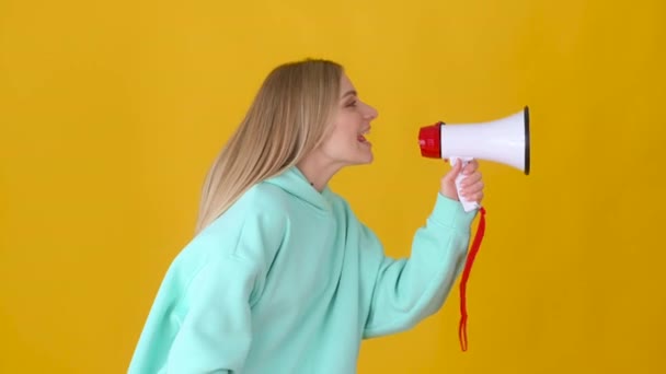 Jong Gelukkig Blond Meisje Praten Met Megafoon Geïsoleerd Gele Achtergrond — Stockvideo