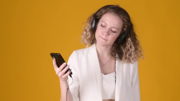 Vrolijk Jong Meisje Met Krullend Haar Met Hoofdtelefoon Luistert Naar — Stockvideo