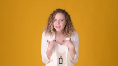 Sarışın, beyaz bir kadın sarı stüdyo arka planında izole edilmiş 