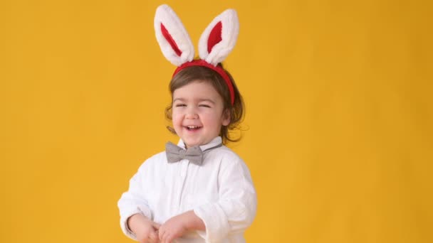 Mały Uroczy Chłopiec Króliczymi Uszami Głowie Jest Zabawy Izolowane Żółtym — Wideo stockowe