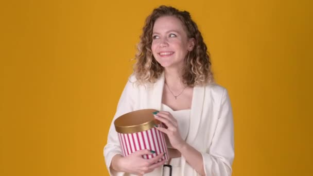 Kıvırcık Saçlı Genç Kız Kırmızı Kutuyu Açıyor Sarı Arka Planda — Stok video