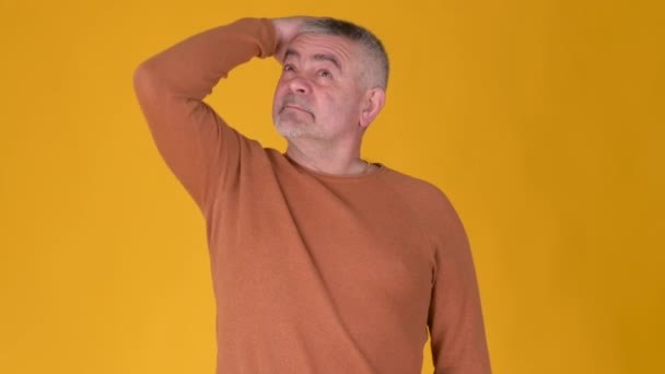 Portrétní Starší Šedovlasý Muž Přemýšlející Nad Obtížnou Volbou Pozadí Žlutého — Stock video