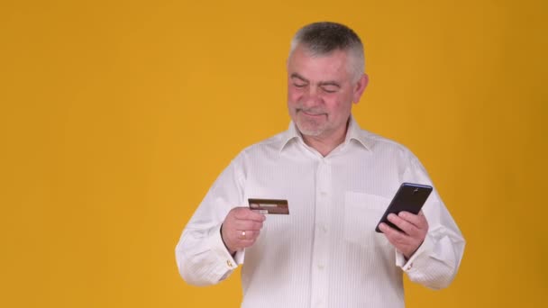 Alegre Homem Cabelos Grisalhos Idosos Usando Celular Segurar Cartão Crédito — Vídeo de Stock