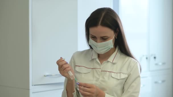 Vrouwelijke Arts Medisch Uniform Beschermend Gelaatsmasker Houdt Een Spuit Vaccinfles — Stockvideo