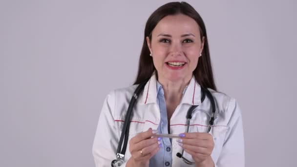 Doctora Uniforme Médico Sostiene Termómetro Médico Comprueba Temperatura Aislada Sobre — Vídeos de Stock