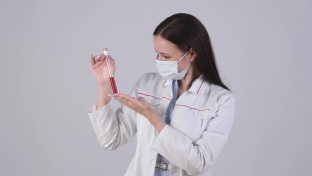 Ärztin Medizinischer Uniform Und Schutzmaske Hält Reagenzglas Mit Blut Isoliert — Stockvideo