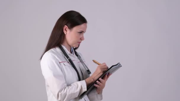 Médica Confiante Medicina Uniforme Observando Registros Clínicos Isolados Fundo Branco — Vídeo de Stock