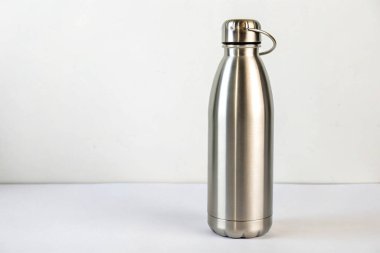 Masanın üzerinde paslanmaz çelik termo su şişesi var..