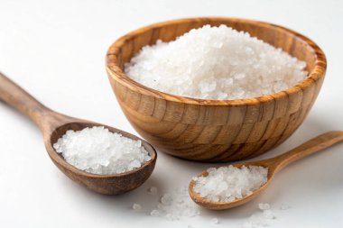 Beyaz arka planda tahta kaşıkta tuz.