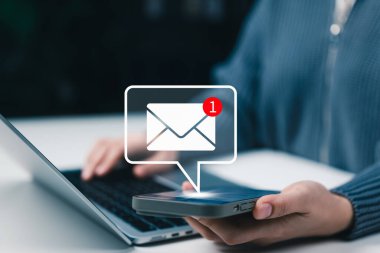 E- posta bildirimi ve online iletişim konsepti. Akıllı telefon kullanan kullanıcı, dizüstü bilgisayar, dijital mesajlaşma ve e- posta uyarıları üzerinde çalışırken zarf bildirim simgesi içeren yeni ileti uyarısı alıyor.