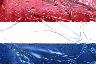 Kırmızı, beyaz ve mavi renkli ıslak bir bayrak, su damlacıklarıyla desenli bir folyo üzerinde,