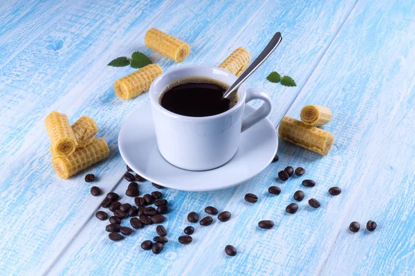 Black coffee in white mug with waffles rolls on a blue backgroun — Stock Photo, Image