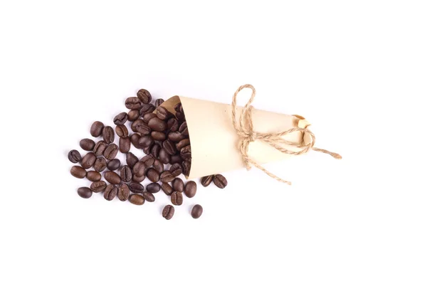 Granos de café en una bolsa de papel. Los granos de café están dispersos aislados — Foto de Stock