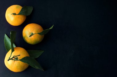 Mandalina yaprakları top ile kara tahta arka plan üzerinde göster