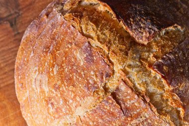 Koyu mavi arka planda ahşap tabakta ev yapımı ekmek..