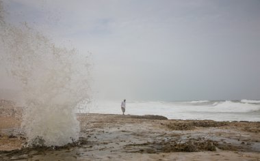 Omani man walking on  beach of Mughsayl clipart