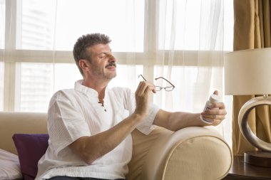 Orta yaşlı adam bir ilaç şişesi okuma