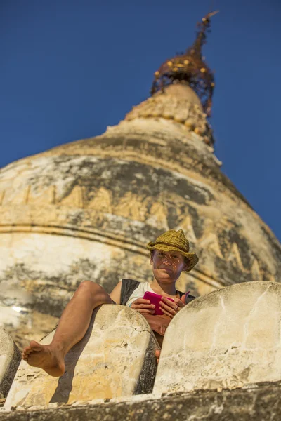 Turista assistindo um telefone de uma stupa de Bagan — Fotografia de Stock