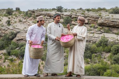 Omani erkekler sepet gül yaprakları holding