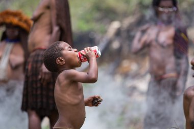 Dani tribe girl  holding Coca Cola clipart