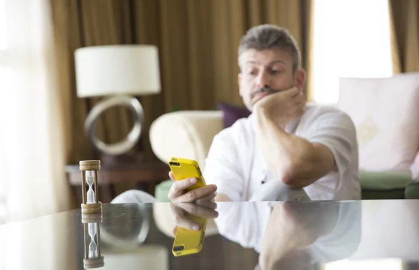 Мужчина средних лет смотрит на телефон — стоковое фото