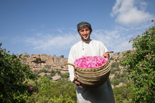 man is showing off basket full of roses