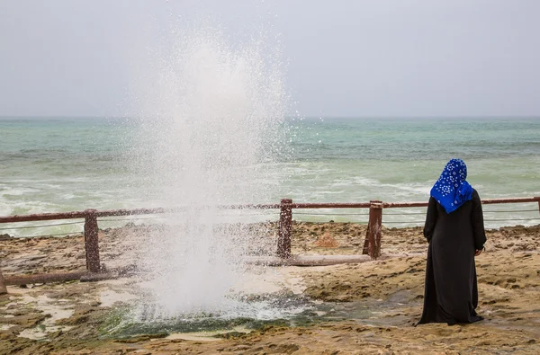 Оманську жінка йде по пляжу Mughsayl — стокове фото