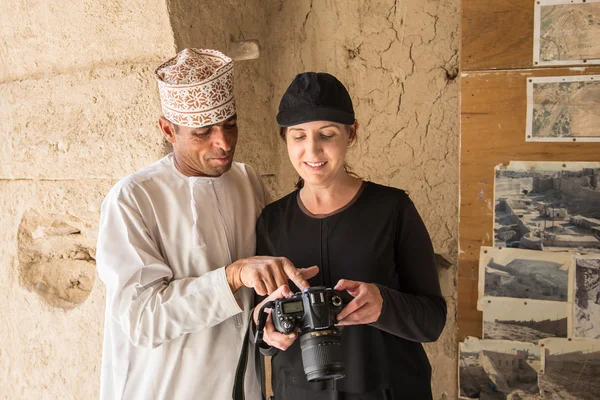 Omani man is pointing out attraction in a camera