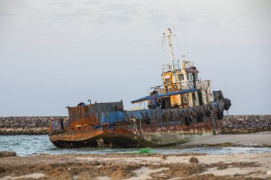 Eski terk edilmiş balıkçı teknesi Sharjah, Birleşik Arap Emirlikleri 'nde bir sahilde paslanıyor.