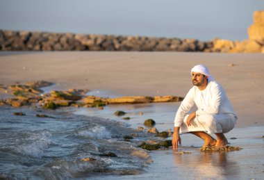 OAE 'de deniz kıyısında oturan yakışıklı bir Arap.